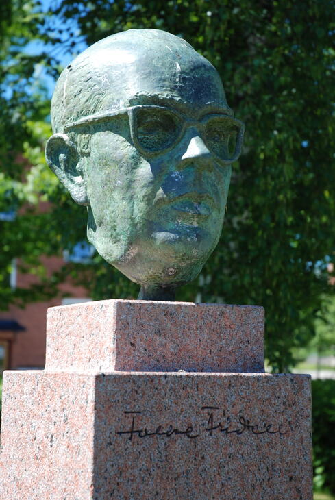 Bronsstaty på Folke Fridell utanför biblioteket i Ljungby. Bysten avtäcktes 1989 av kulturministern Bengt Göransson. Konstnär: Maire Männik.